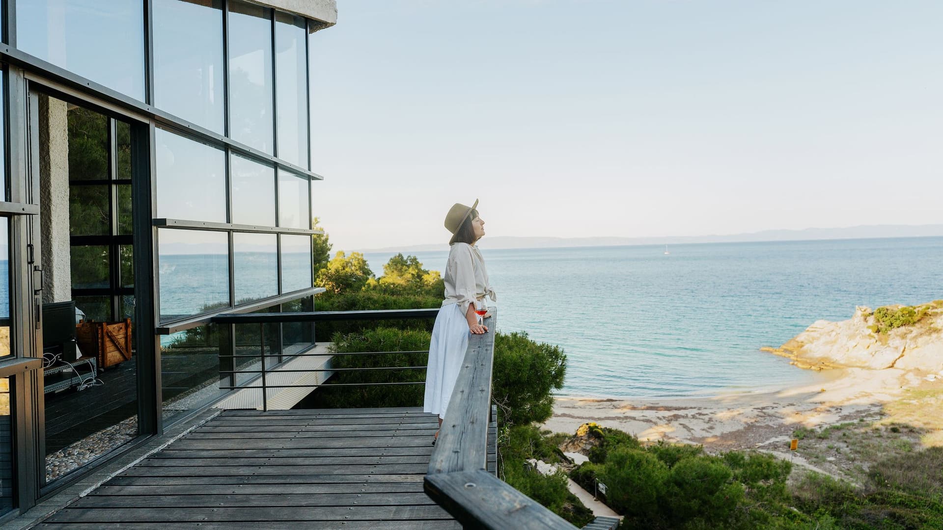 frau-steht-auf-terasse-mit-wein-GI-2250696337-4000kb-original