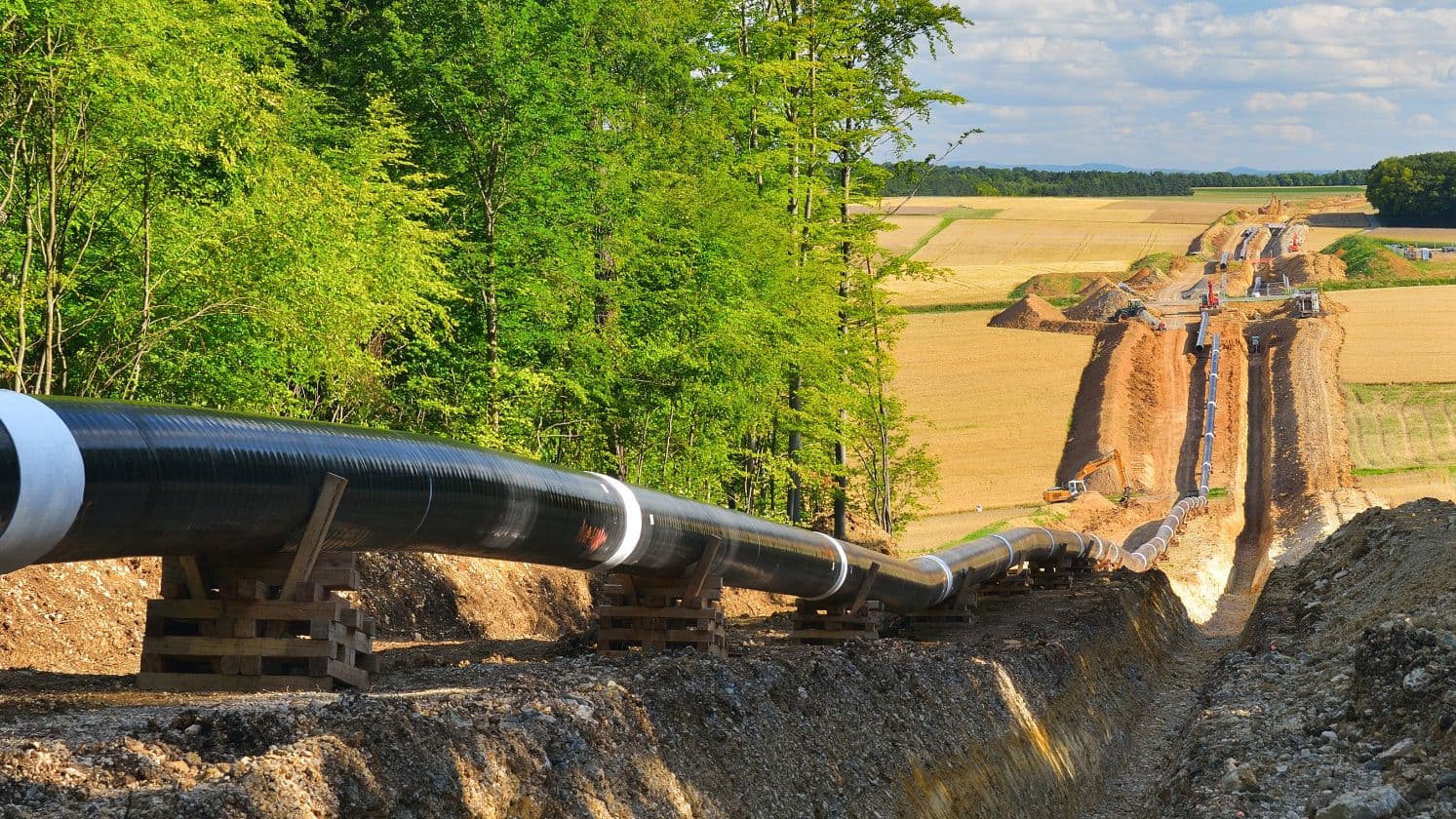 Gaspipeline wird durch eine Erdgrabung in ländlicher Landschaft verlegt