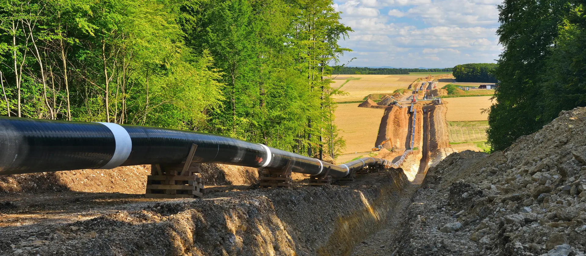 Gaspipeline wird durch eine Erdgrabung in ländlicher Landschaft verlegt
