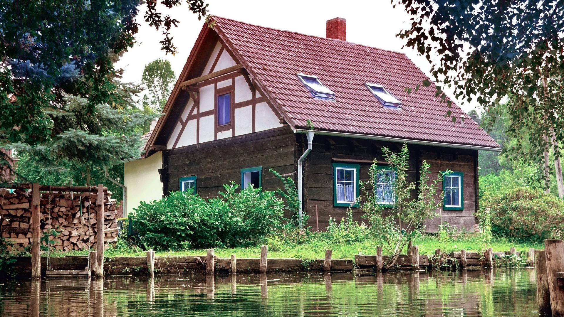 Ein Fachwerkhaus an einem Flußufer im Spreewald.