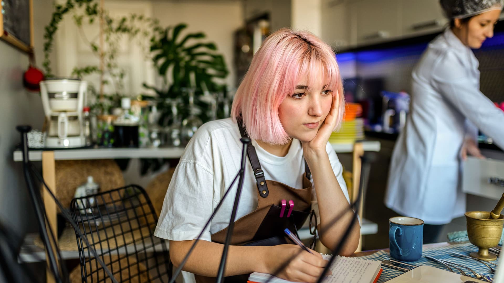 Studentin macht eine Lernpause während ihrer Arbeitszeit im Cafè.