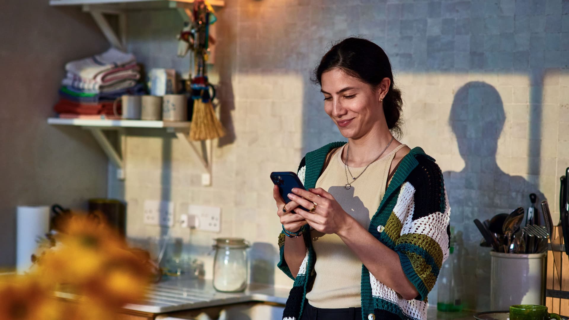 Lächelnde Frau mittleren Alters nutzt soziale Medien auf Smartphone