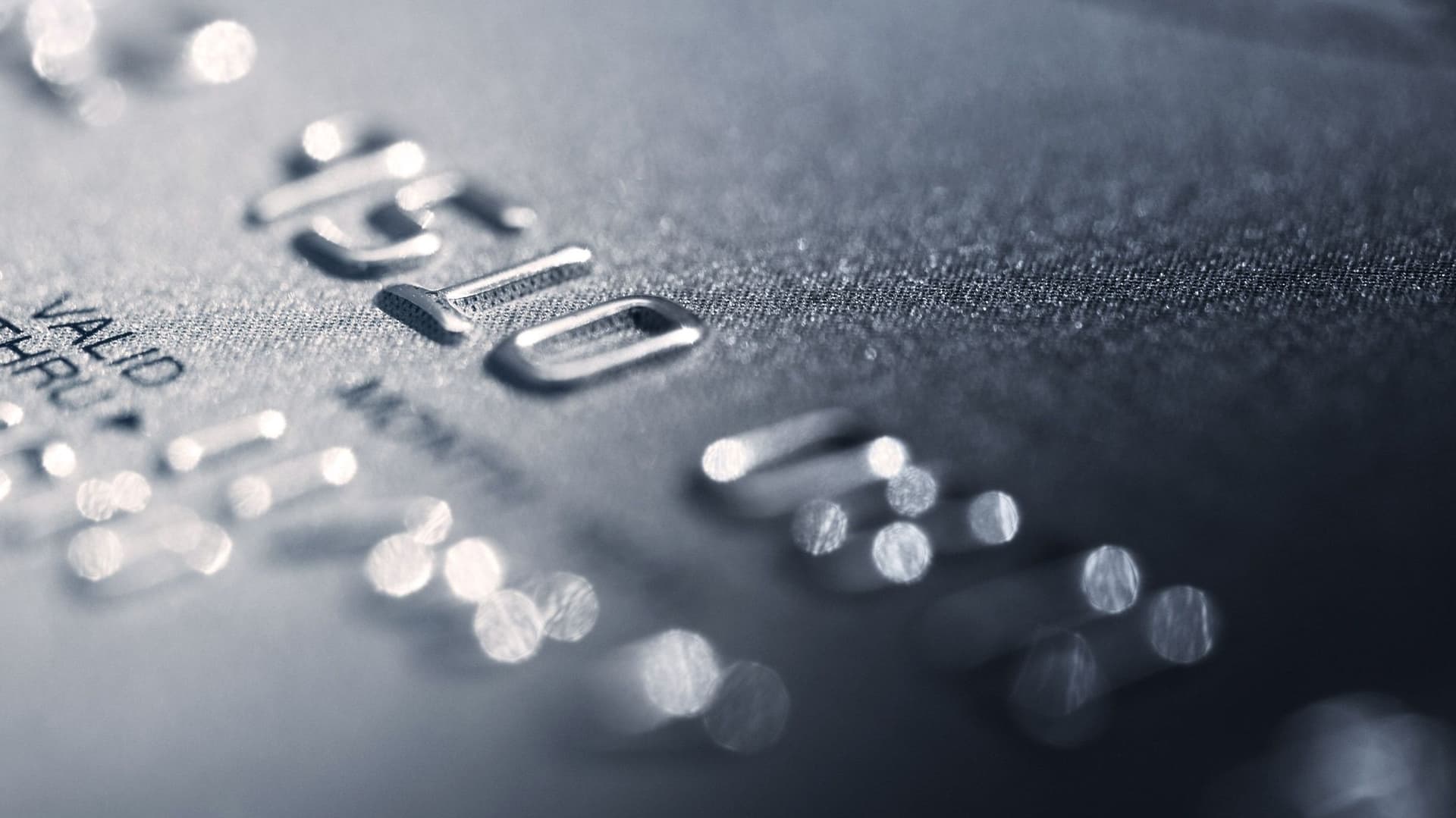 Nahaufnahme einer silbernen Kreditkarte auf der nur ein Ausschnitt der Nummer zu erkennen ist. Das Bild ist leicht seitlich aufgenommen worden und weißt eine hohe Unschärfe auf.